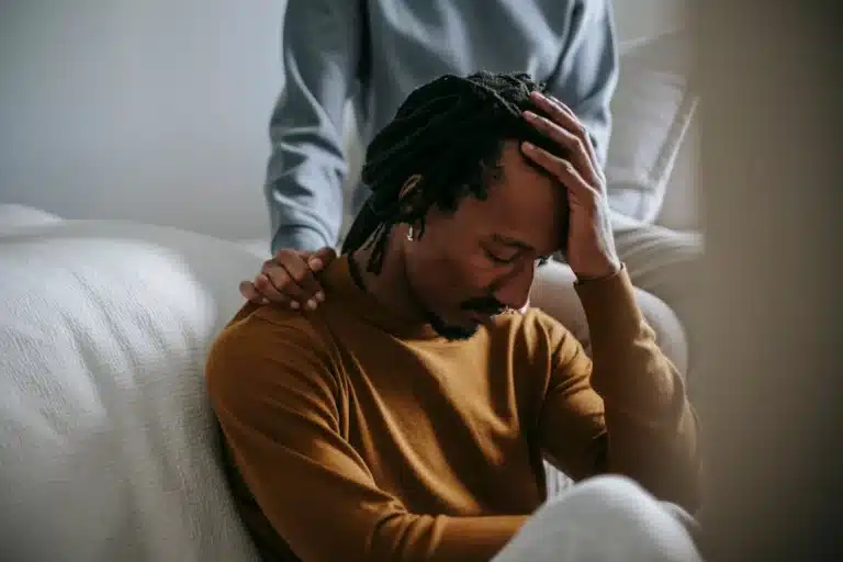 Sorrowful-black-man-touching-head-in-dismay-near-supporting-wife