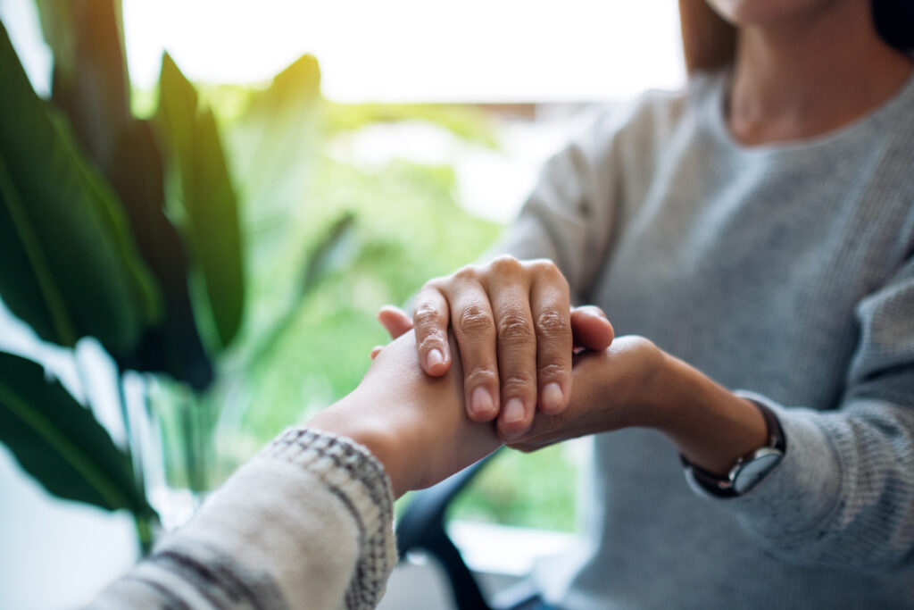 Person holding a friend's hands in support, crisis help for mental health in Frederick MD