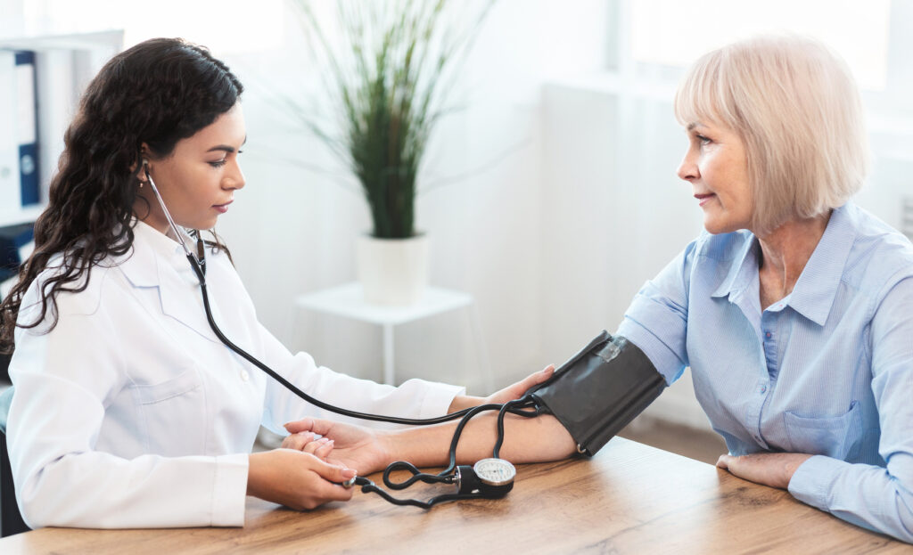 Clinician checking a patient's blood pressure during in-office treatment monitoring