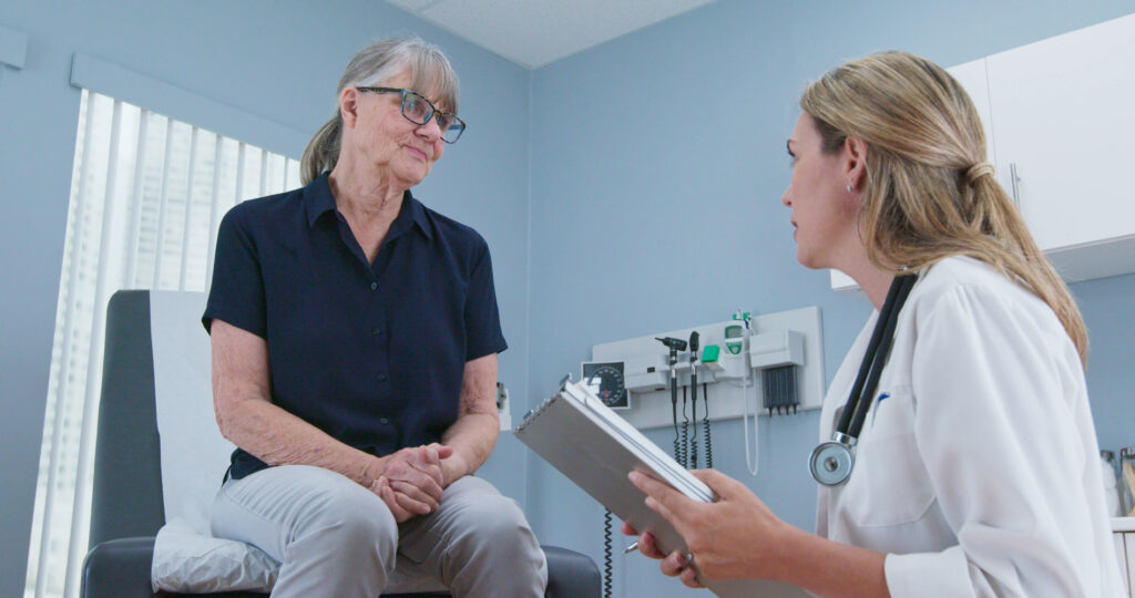 Primary care doctor reviewing health history with an older patient before a psychiatry referral