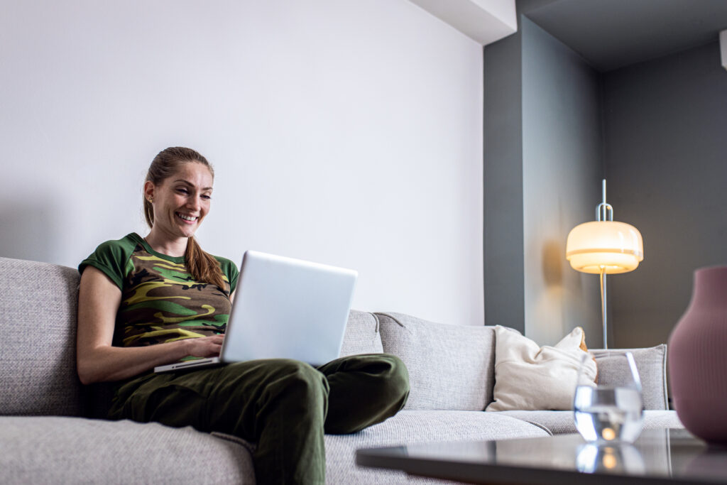 Woman in a camouflage t-shirt on a secure video visit from home, a telehealth psychiatry follow-up in Maryland